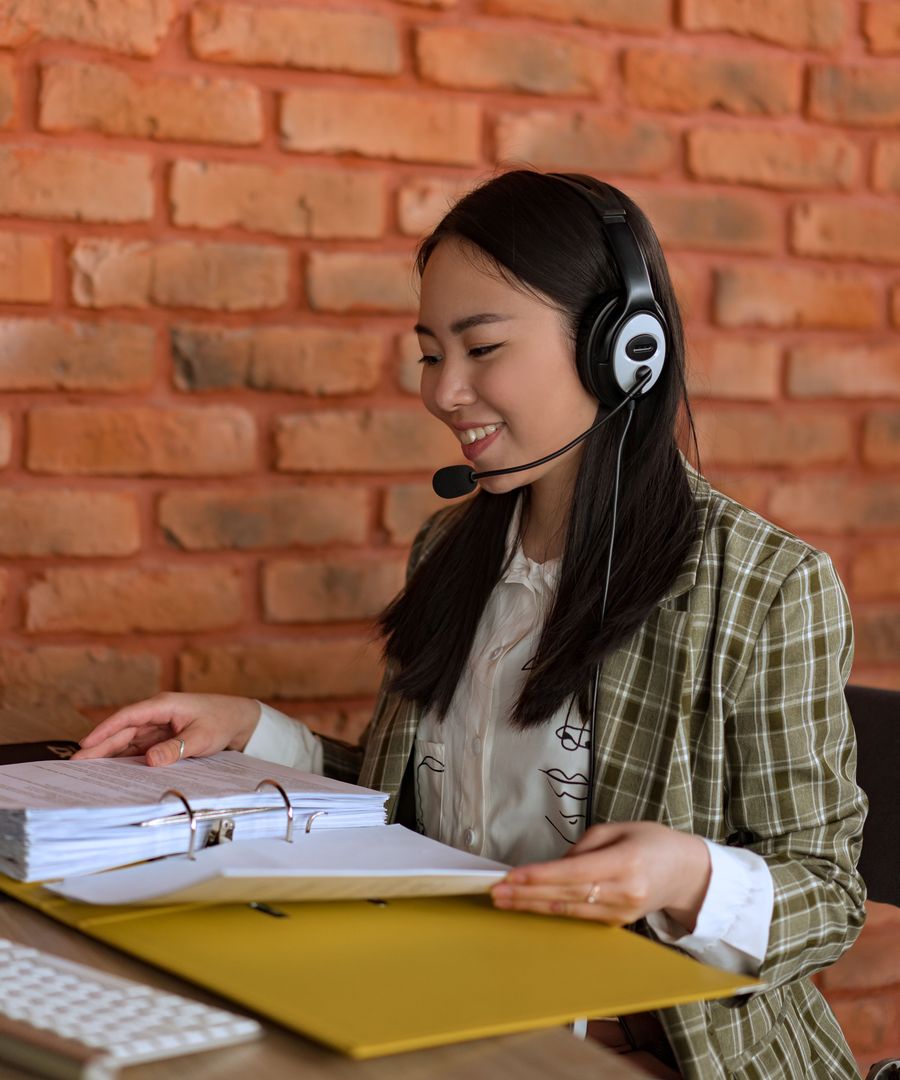A caller with a headset reviewing notes